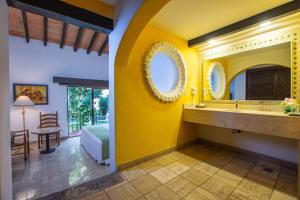 巴亚尔塔港布埃纳文图拉庄园墨西哥魅力酒店 - 全包 的一间带黄色墙壁和水槽的浴室以及一间卧室