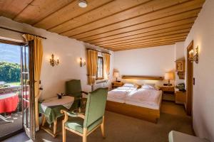 巴特莱辛哈尔Landhotel Sonnleiten的酒店客房带一张床、一张桌子和椅子