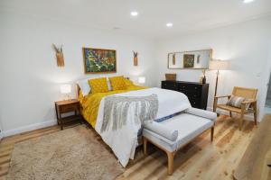 莫尔特里Urban Farmhouse with a Modernism Twist! home的一间卧室配有一张带黄毯和椅子的床