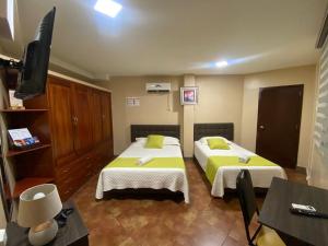 曼塔YORMARI HOTEL的酒店客房设有两张床和电视。