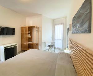 CavoliHotel Lorenza B&B e Mini Suite的一间卧室配有一张床、一张书桌和一台电视。