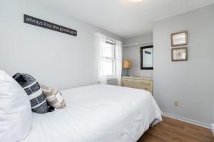 汉普顿Hampton Beach Seaside Villa Unit 1的卧室配有白色的床和窗户。