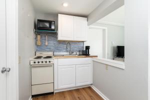 汉普顿Hampton Beach Seaside Villa Unit 1的白色的厨房配有炉灶和微波炉。