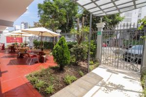 利马伦库米拉弗洛雷斯酒店的一个带桌椅和遮阳伞的庭院