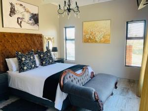 克龙斯塔德Retief Guest Farm的一间卧室配有一张带椅子和吊灯的床。