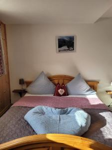 纳瑟尔文勒Große Ferienwohnung in Nesselwängle的一间卧室配有一张带心枕的床