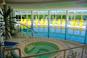 巴德瓦尔特斯多夫Ferienhaus in Wagerberg mit Garten, Terrasse und Whirlpool的游泳池设有热水浴池和黄色椅子