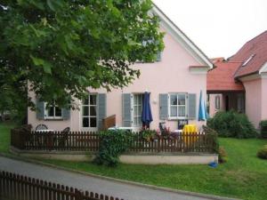 巴德瓦尔特斯多夫Ferienhaus in Wagerberg mit Garten, Terrasse und Whirlpool的院子内带雨伞的围栏的房子