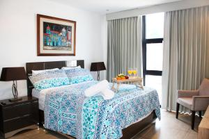 圣萨尔瓦多The Luxury Apartment的一间卧室配有一张床和一张带水果的桌子