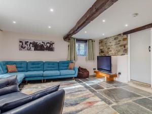 Otterham5 Bed in Crackington Haven 80628的客厅配有蓝色的沙发和平面电视。