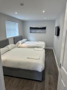 利物浦Smeaton street rooms的一间卧室设有两张床,墙上配有电视。