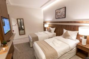 麦加Wassad Hotel Makkah فندق وسد مكة的酒店客房设有两张床和电视。