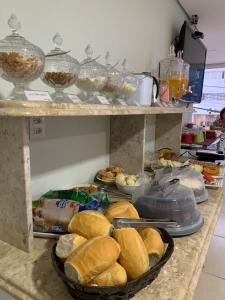 马里利亚Hotel Flat Almaru - Marília的柜台有一大堆三明治和其他食物