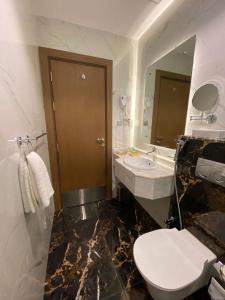 麦加Wassad Hotel Makkah فندق وسد مكة的一间带卫生间、水槽和镜子的浴室
