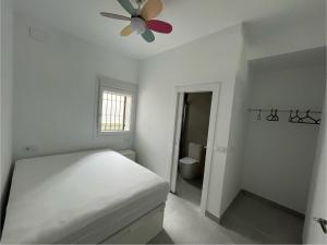 巴埃萨Baeza aloja的白色卧室配有床和吊扇