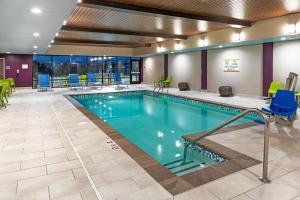 韦瑟福德Home2 Suites By Hilton Weatherford的游泳池位于酒店客房内,配有桌椅