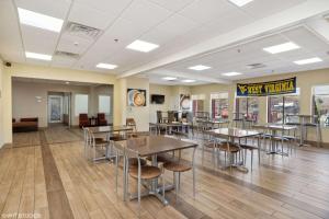摩根敦Quality Inn & Suites Morgantown - University Area的自助餐厅内带桌椅的用餐区