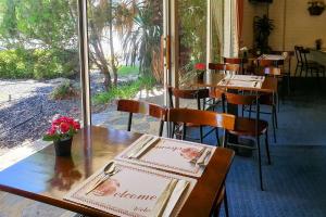 珀斯Econo Lodge Rivervale的餐厅设有木桌和鲜花椅子