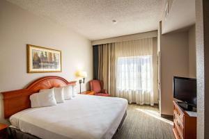 埃尔多拉多Country Inn & Suites by Radisson, El Dorado, AR的酒店客房,配有床和电视