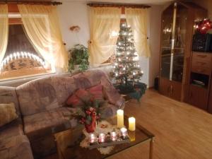 CrottendorfFerienhaus Erzgebirge Familie Ziller, Crottendorf的客厅配有圣诞树和蜡烛