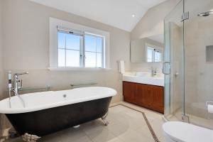 奥克兰Grande Vista 5Br Manor with Pool & Mt Eden Views的带浴缸、盥洗盆和卫生间的浴室