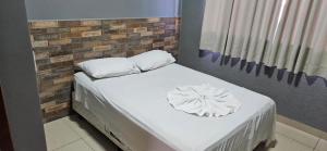 普鲁登特总统城伊塔维拉二号酒店的一张带白色床单和枕头的床