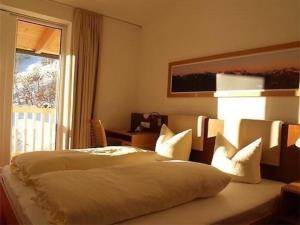 卡普尔Appartement in Kappl mit Eigenem Balkon的卧室配有带枕头的床铺和窗户。