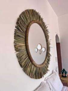 马拉喀什Aghmat Lodge Guest house的墙上的金色镜子,里面装有两枚环