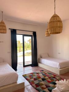 马拉喀什Aghmat Lodge Guest house的一间卧室设有两张床和窗户。