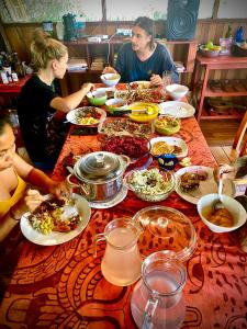 普卡尔帕Jungle Lodge with lookout tower的一群人坐在桌子旁吃着食物
