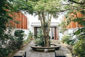 伊万里市伊万里中央酒店 的庭院里种着树,设有两个长椅