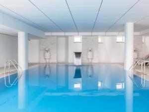 佩尼契MH佩尼切酒店的白色房间中的一个蓝色海水游泳池