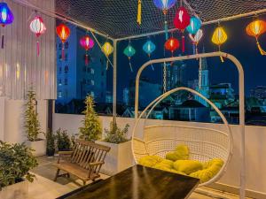 胡志明市Saigon Hotel & Apartment的阳台配有桌椅和色彩缤纷的灯笼。