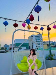 胡志明市Saigon Hotel & Apartment的女人坐在带灯笼的椅子上