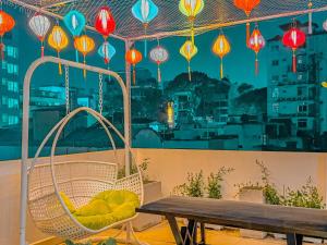 胡志明市Saigon Hotel & Apartment的阳台配有吊床和桌子,阳台配有灯笼