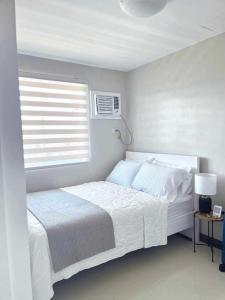 公主港Palawan Paradise Condotel 6F的白色的卧室设有床和窗户
