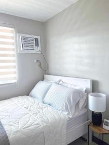 公主港Palawan Paradise Condotel 6F的卧室配有白色的床和空调