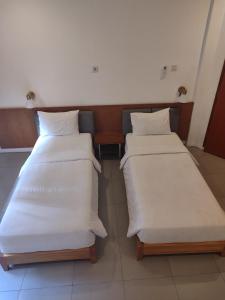 三宝垄迪亚扬蒂住宿加早餐旅馆的配有白色床单的酒店客房内的两张床