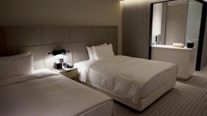 高雄Greet Inn 喜迎旅店的酒店客房设有两张床和盥洗盆