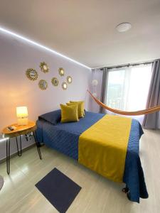 马尼萨莱斯Suite con hamaca y baño privado.的一间卧室配有蓝色和黄色的床和一张桌子