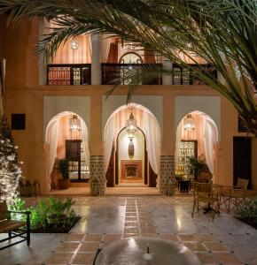 马拉喀什Riad Dar Al Dall - This Time Tomorrow in Marrakech的棕榈树建筑的大堂