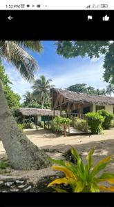 LénakelWhite Beach Bungalow & Restaurant的前面有棕榈树的房子