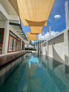 哈德超珊兰Chao Sam Ran Pool Villa Phetchaburi หาดเจ้าสำราญ เพชรบุรี ราคาสำหรับ 8 ท่าน的一座拥有木制天花板和蓝色海水的室内游泳池