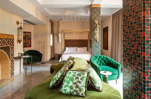 马拉喀什Riad Dar Al Dall - This Time Tomorrow in Marrakech的酒店客房,配有一张床和一把绿色椅子