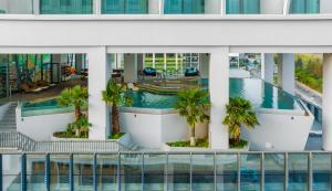 岘港Awaken Da Nang Hotel的享有带游泳池和棕榈树的建筑的空中景致