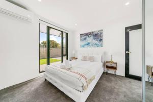 悉尼King’s Deluxe in Newtown的白色卧室设有大床和大窗户