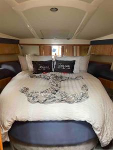 埃格姆ENTIRE LUXURY MOTOR YACHT 70sqm - Oyster Fund - 2 double bedrooms both en-suite - HEATING sleeps up to 4 people - moored on our Private Island - Legoland 8min WINDSOR THORPE PARK 8min ASCOT RACES Heathrow WENTWORTH LONDON Lapland UK Royal Holloway的船后方的一张大床