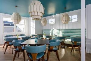 纳拉甘西特The Break Hotel的餐厅设有蓝色的桌椅和吊灯。