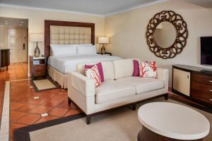 圣詹姆斯The House by Elegant Hotels - All-Inclusive, Adults Only的一间卧室配有一张床、一张沙发和一面镜子