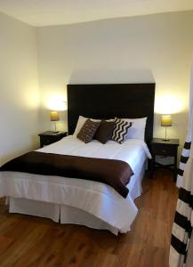 昆卡NASS Bed & Breakfast的一间卧室配有一张带两盏灯的大型白色床。